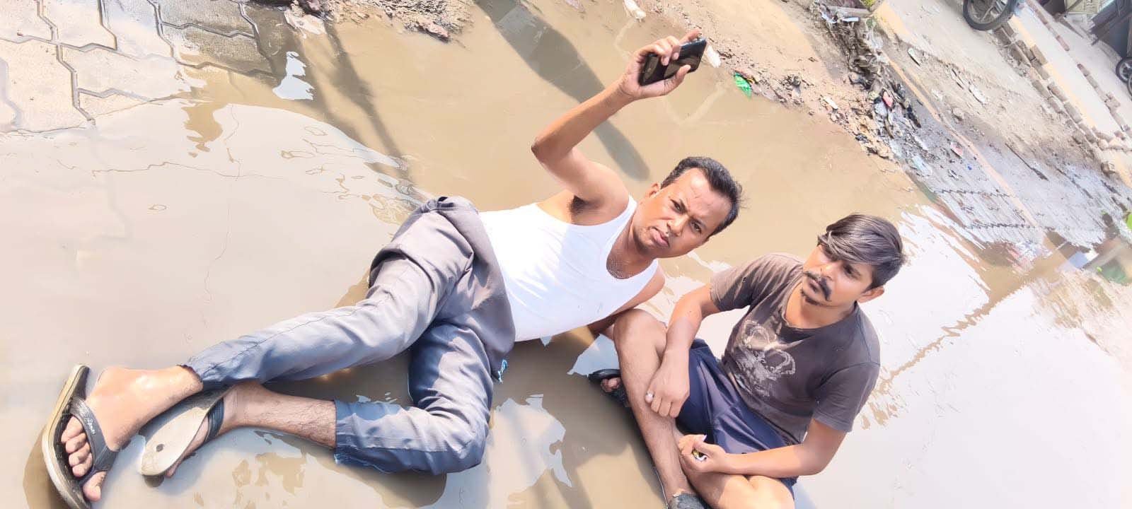 राजातालाब में अनोखा विरोध: सीवर के गंदे पानी के बीच सड़क पर लेटकर युवक ने जताया आक्रोश